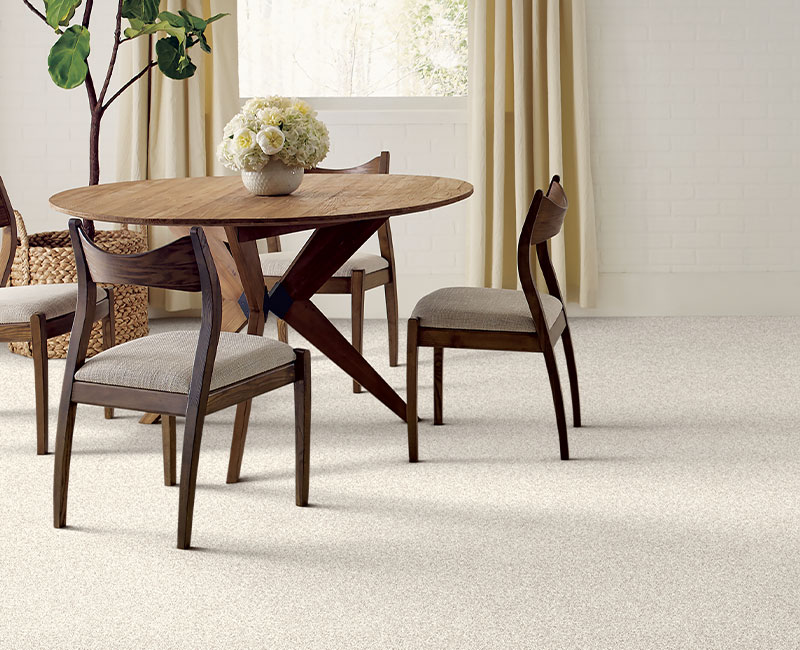 light gray carpet in dining room with dining table and chairs